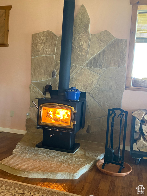 Details with a wood stove and dark hardwood / wood-style floors