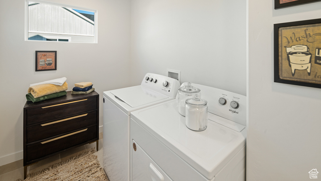Washroom with washer hookup, washer and clothes dryer, and light tile flooring