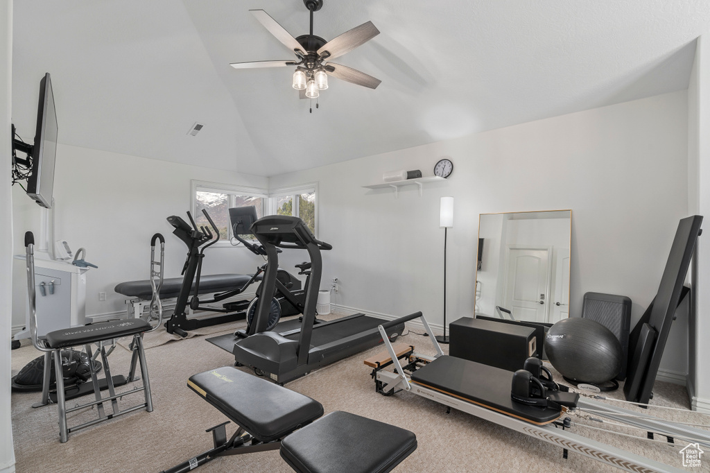 Workout room featuring ceiling fan, light carpet, and high vaulted ceiling