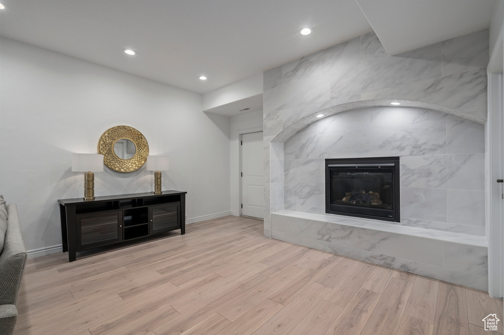 Living room featuring a tile fireplace and light hardwood / wood-style floors