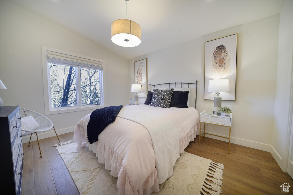 Bedroom featuring lofted ceiling and hardwood / wood-style flooring
