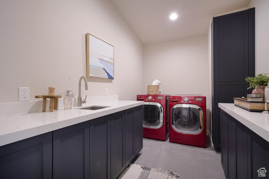 Laundry area with sink, washing machine and dryer, cabinets, and light tile floors