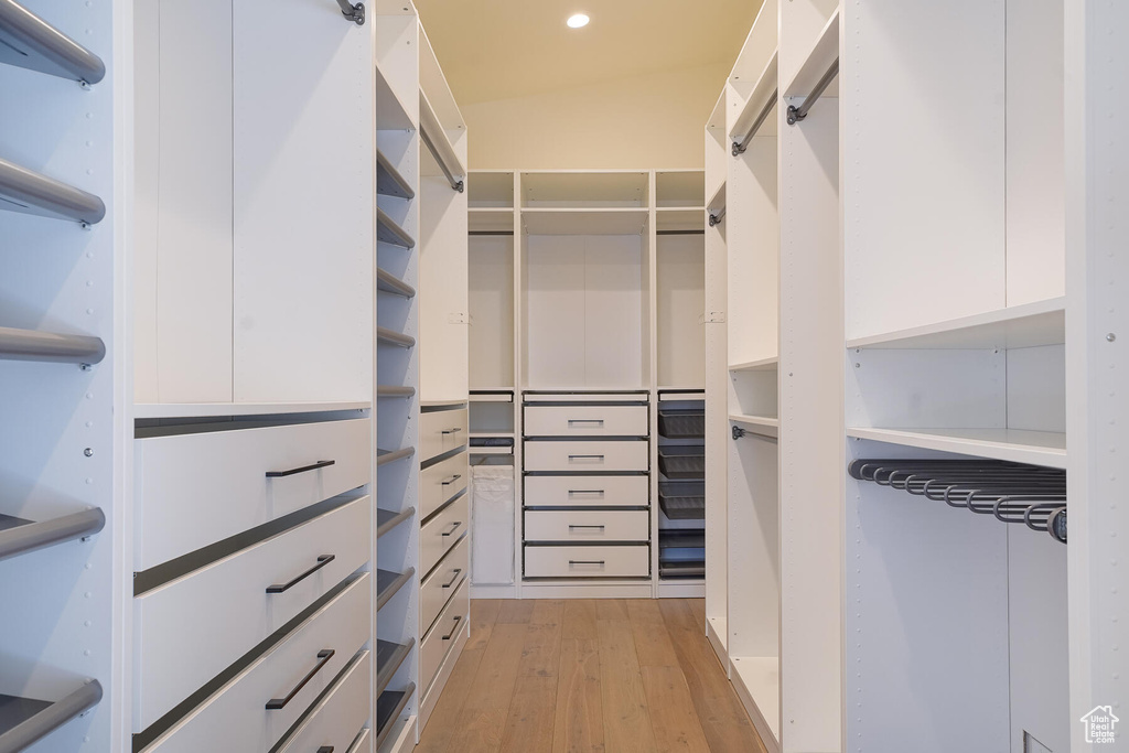 Spacious closet with lofted ceiling and light wood-type flooring