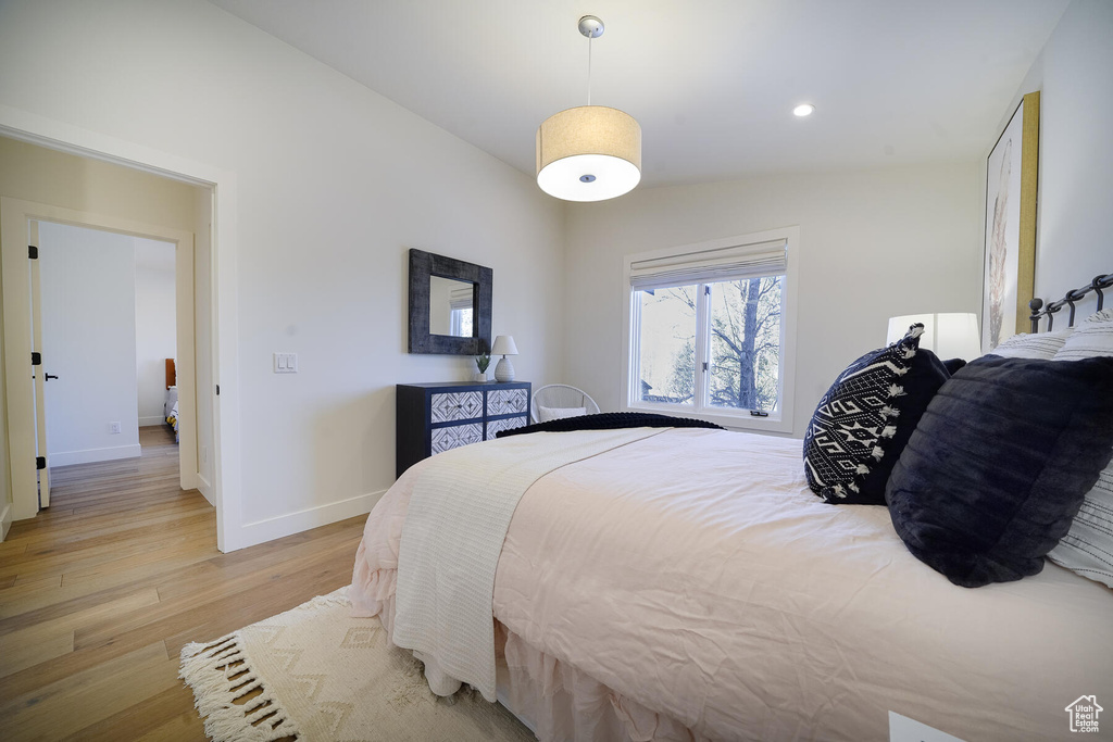 Bedroom with vaulted ceiling and light hardwood / wood-style floors