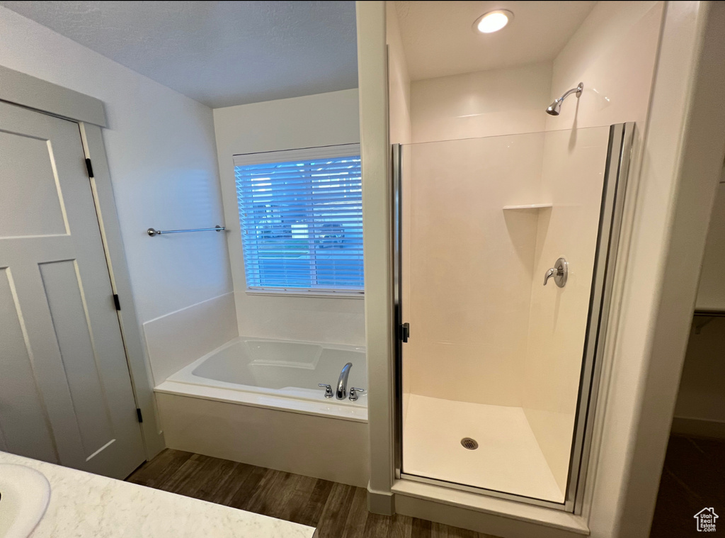 Bathroom featuring separate shower and tub and hardwood / wood-style floors