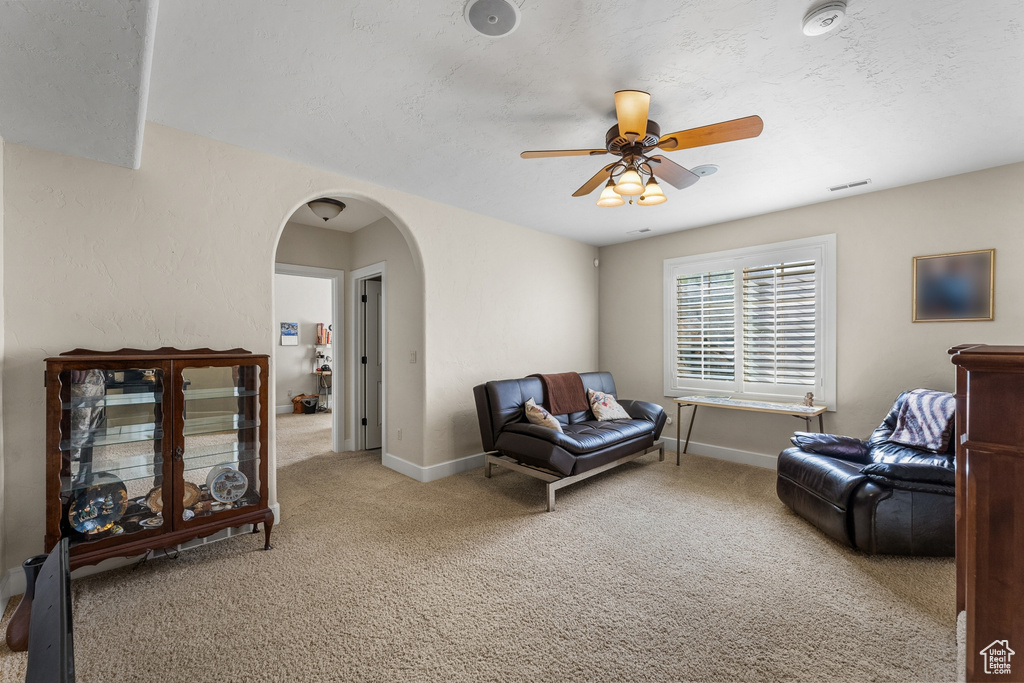 Sitting room with ceiling fan and light colored carpet