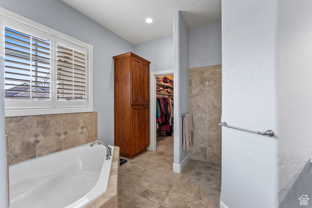 Bathroom featuring tiled bath and tile flooring