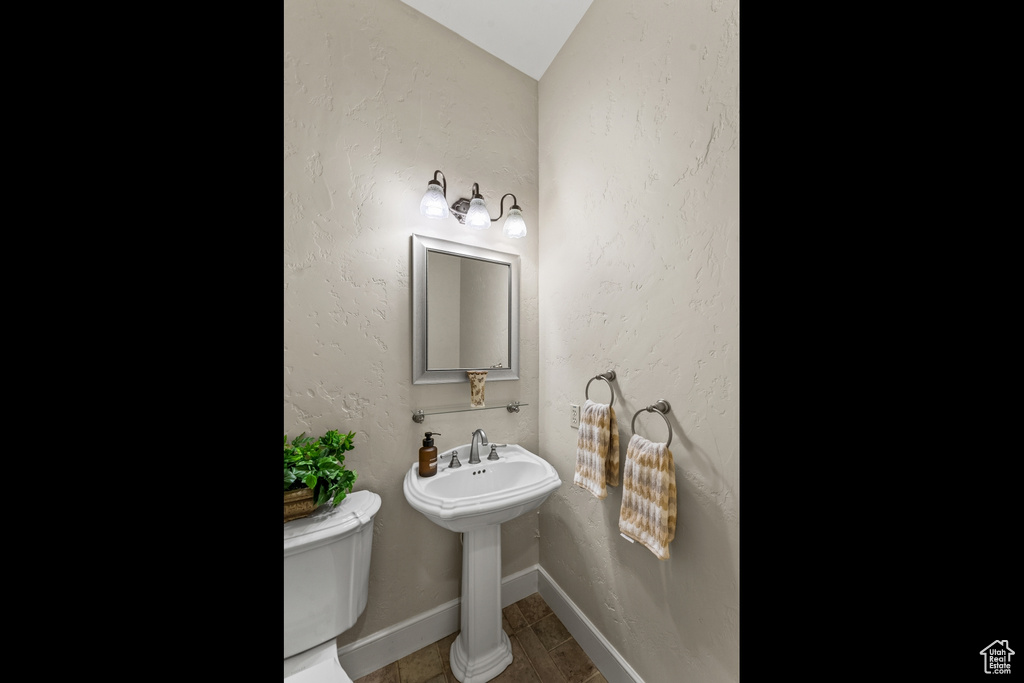 Bathroom with tile flooring, toilet, and vaulted ceiling