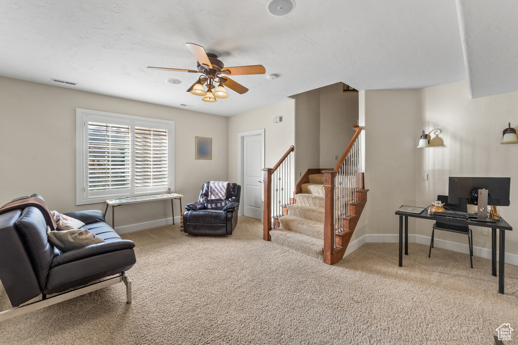 Living area with light colored carpet and ceiling fan