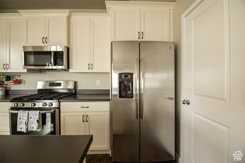 Kitchen featuring white cabinets and appliances with stainless steel finishes