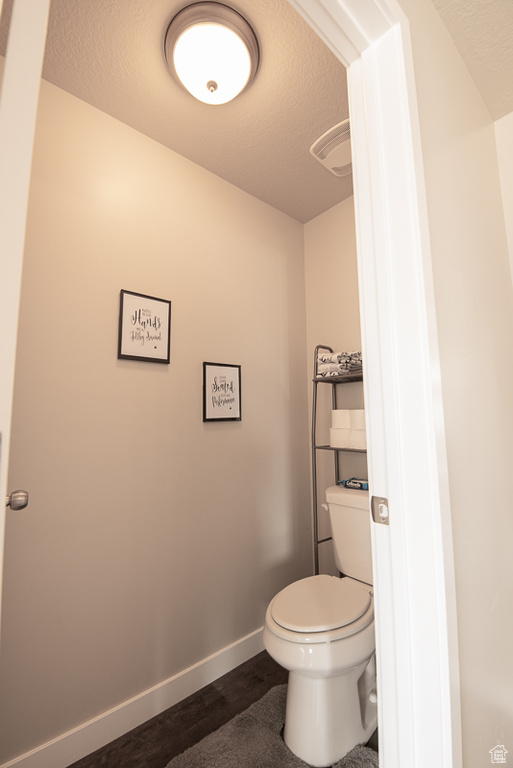 Bathroom with a textured ceiling and toilet