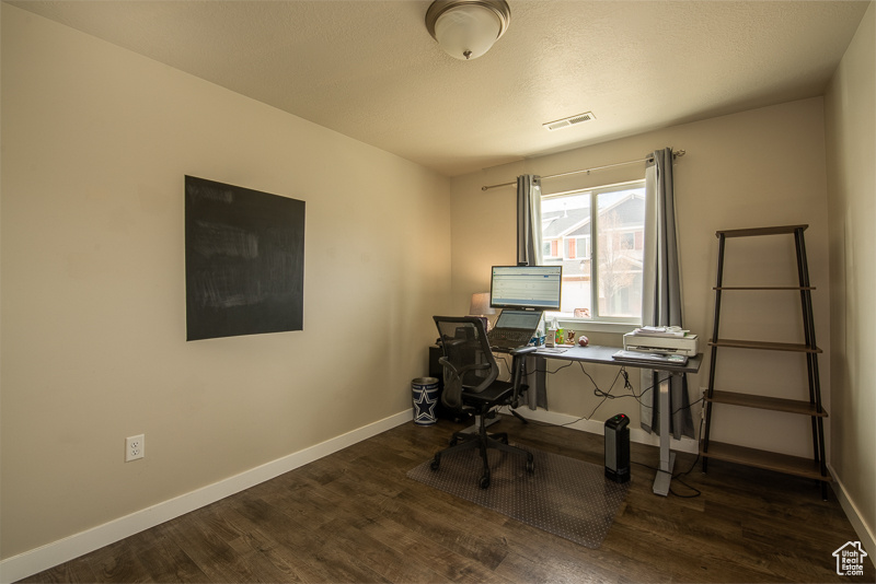 Office area with dark hardwood / wood-style flooring
