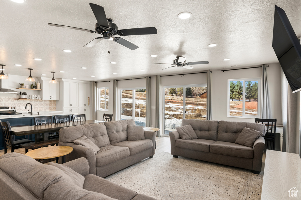 Living room featuring a textured ceiling, ceiling fan, and sink