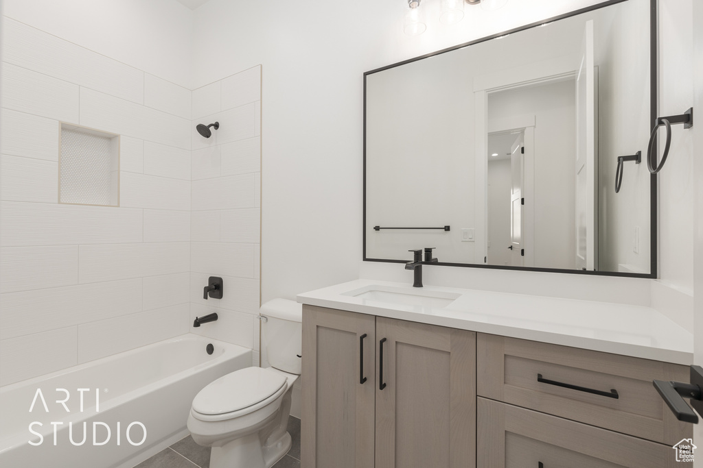 Full bathroom featuring tiled shower / bath, toilet, tile flooring, and large vanity