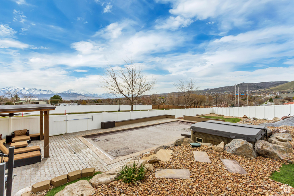 View of yard featuring a patio, a mountain view, and a hot tub
