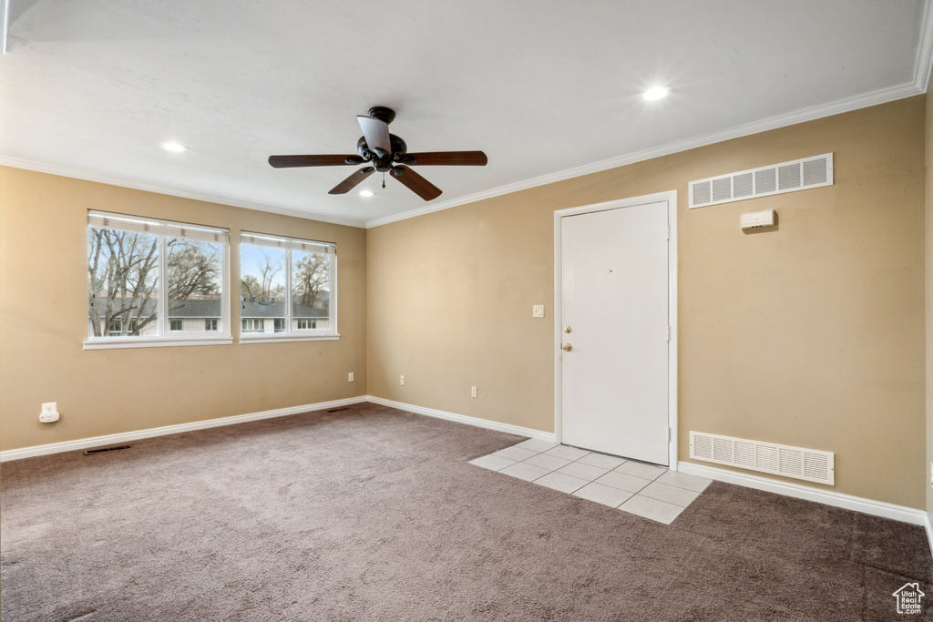 Carpeted empty room with ceiling fan and crown molding