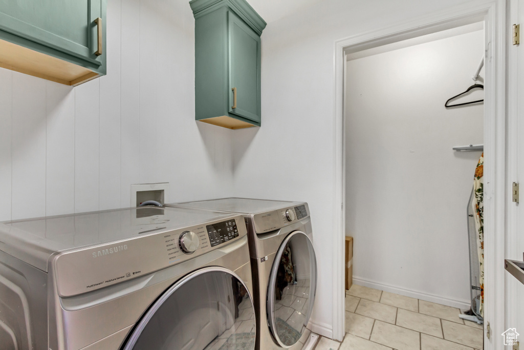 Washroom with independent washer and dryer, cabinets, light tile floors, and hookup for a washing machine
