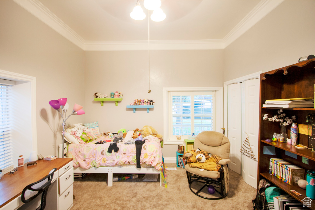 Bedroom with a closet, light carpet, crown molding, and ceiling fan