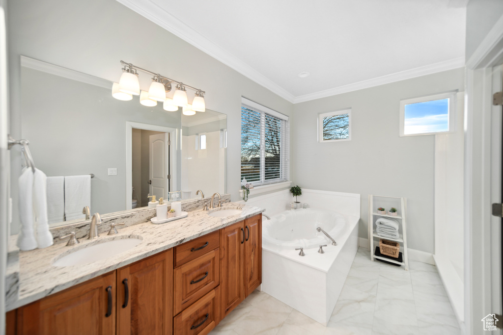 Bathroom featuring dual sinks, crown molding, tile flooring, large vanity, and a washtub