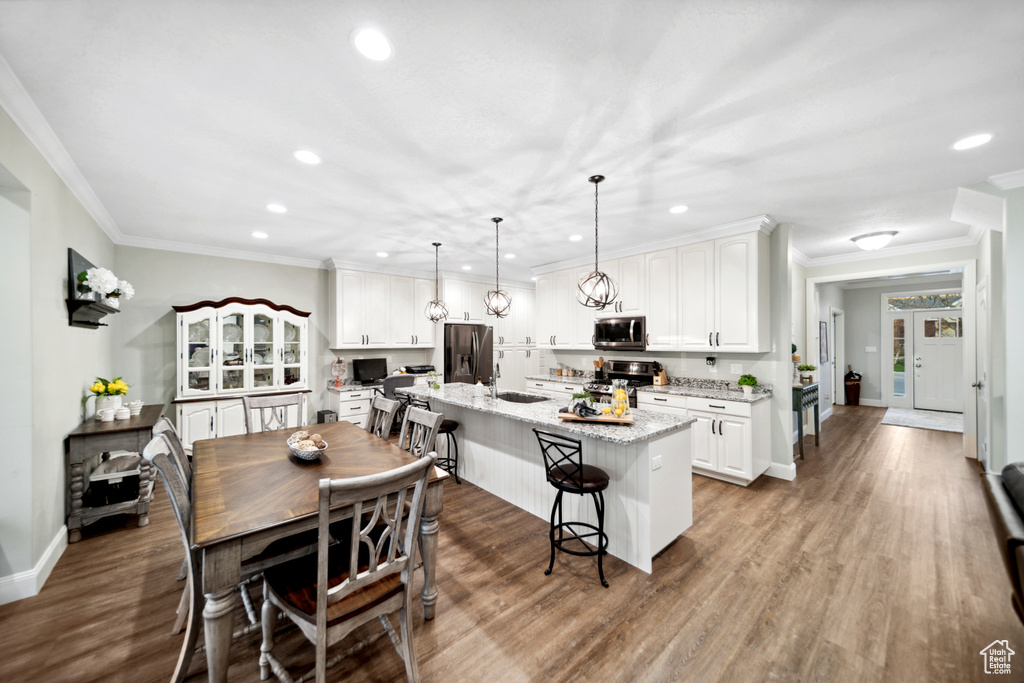 Kitchen with white cabinets, stainless steel appliances, and hardwood / wood-style floors