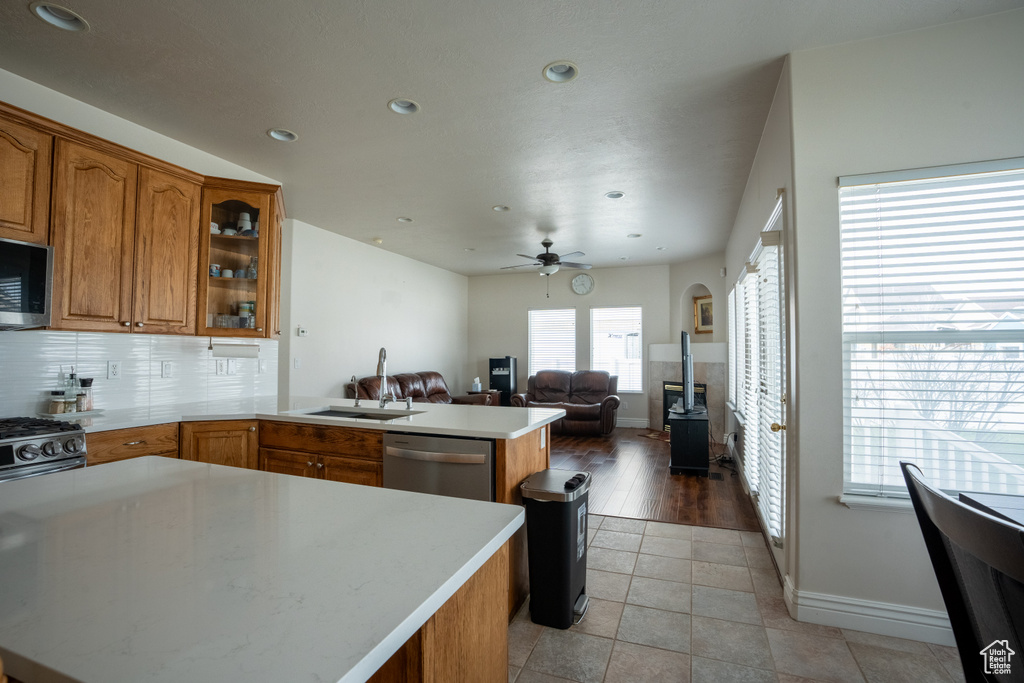 Kitchen with stainless steel appliances, light tile floors, ceiling fan, tasteful backsplash, and sink