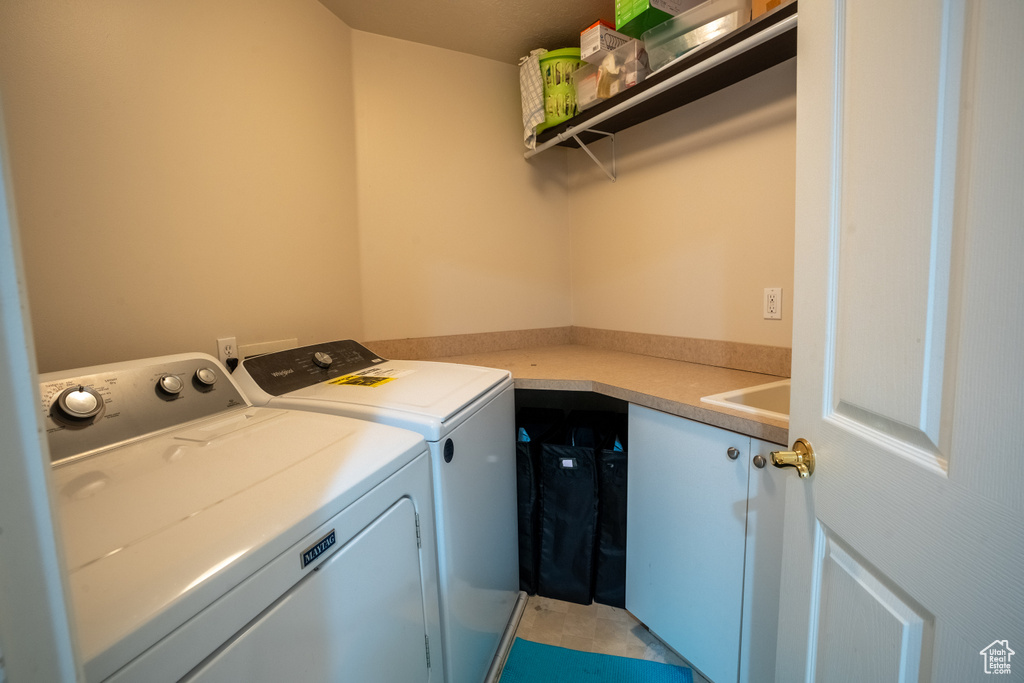 Laundry area featuring separate washer and dryer and light tile floors