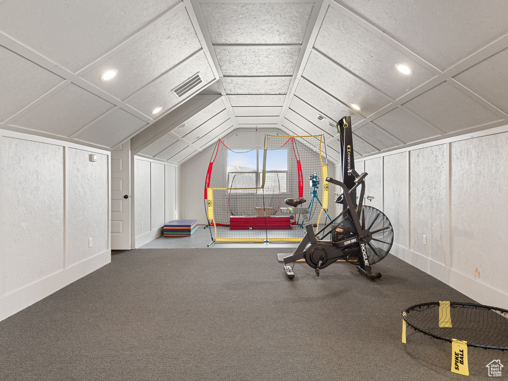 Workout area featuring coffered ceiling, carpet floors, and vaulted ceiling