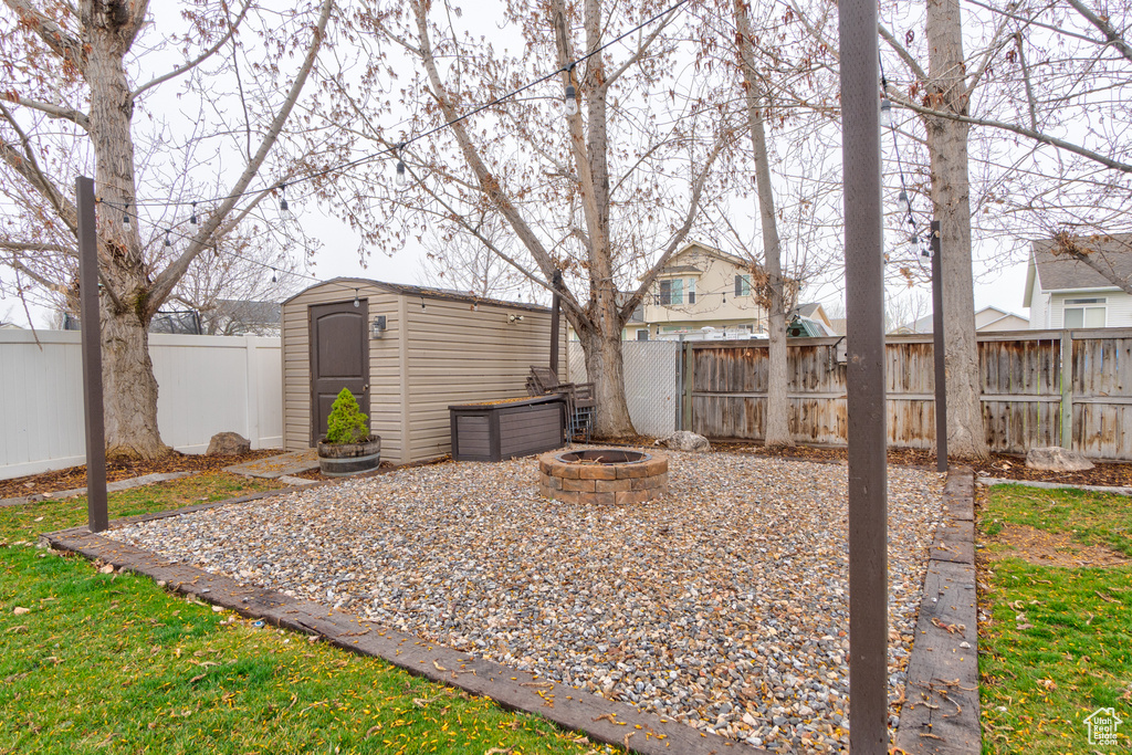 View of yard featuring a fire pit and a storage shed