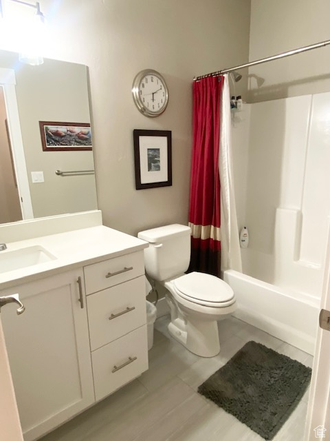 Full bathroom featuring shower / tub combo with curtain, tile floors, toilet, and vanity