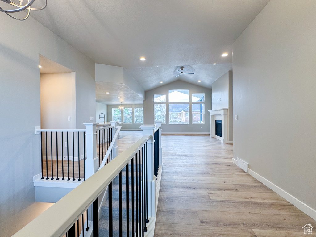 Hallway featuring vaulted ceiling and light hardwood / wood-style flooring