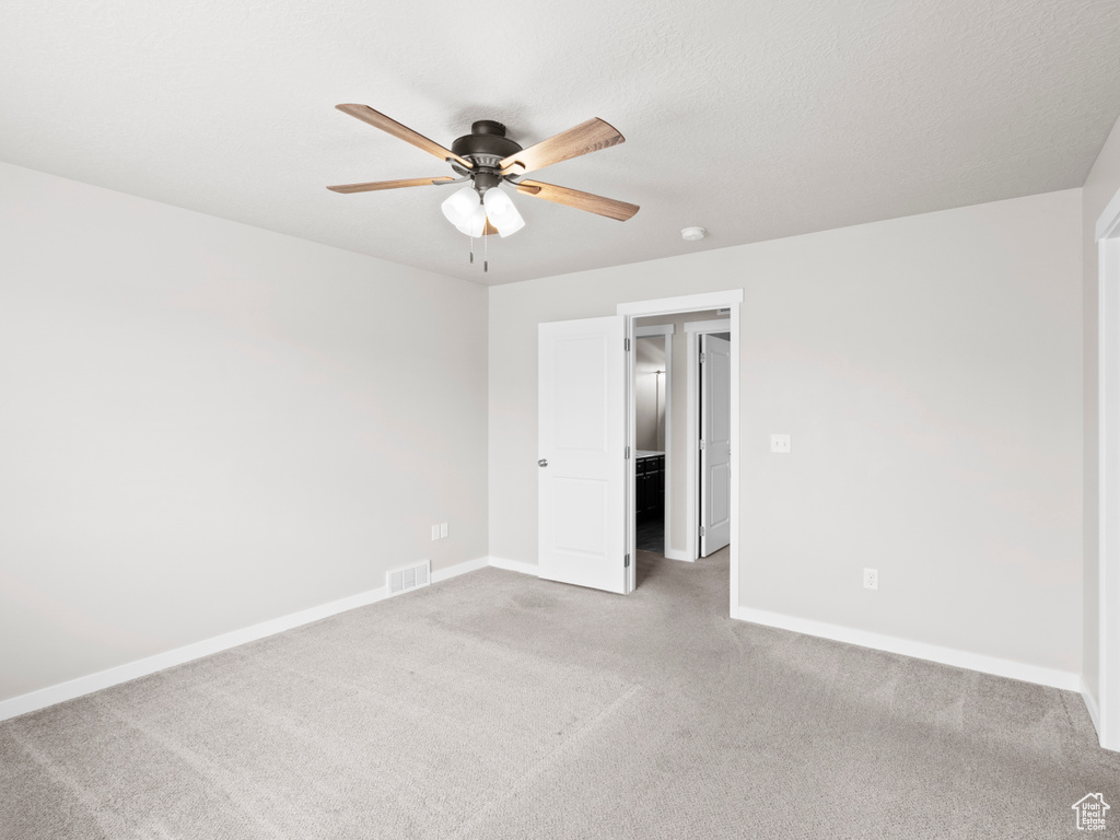 Spare room with ceiling fan and light colored carpet