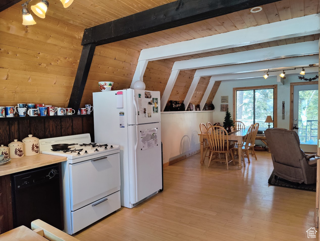 Kitchen with white appliances, light hardwood / wood-style floors, and lofted ceiling with beams