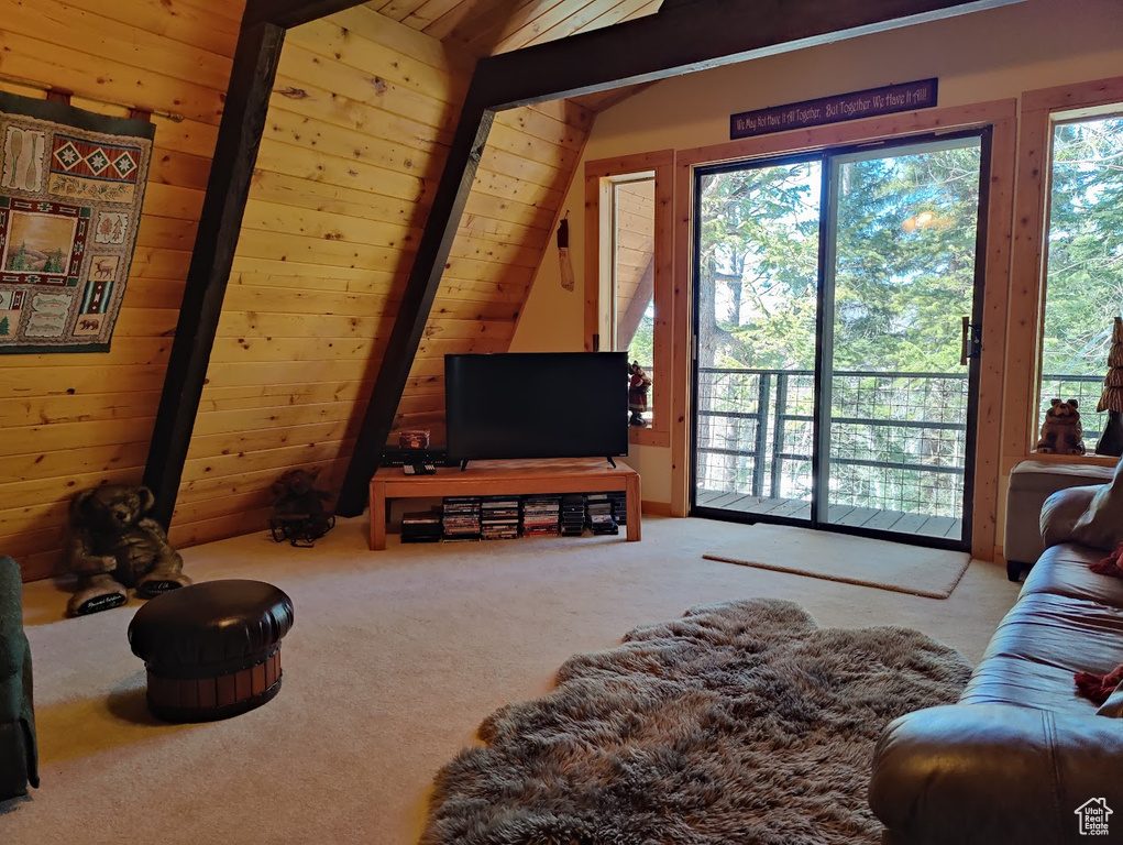 Carpeted living room featuring lofted ceiling with beams