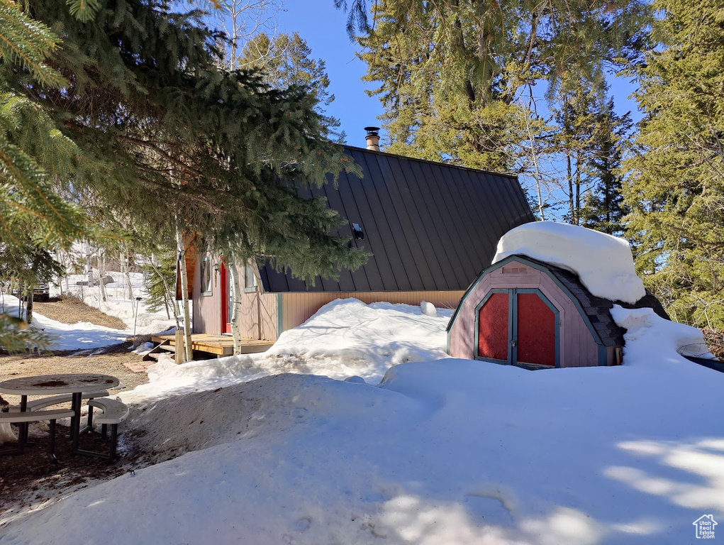 View of snowy exterior with a storage shed