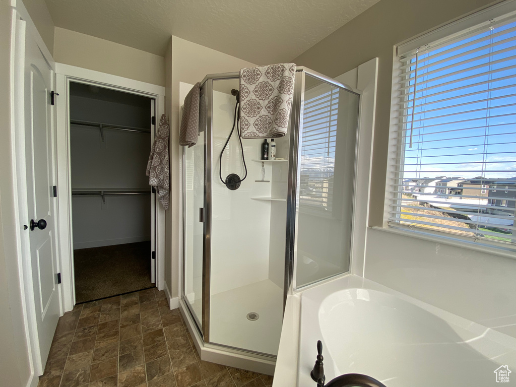 Bathroom featuring plus walk in shower and tile floors