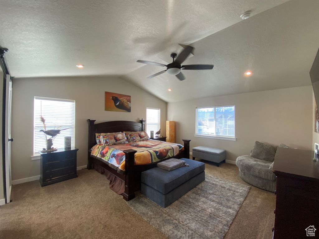 Bedroom with ceiling fan, a textured ceiling, carpet floors, and vaulted ceiling