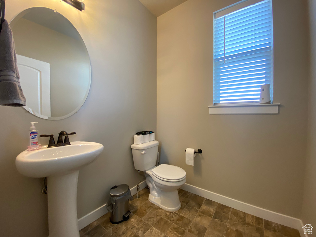 Bathroom with tile flooring, a wealth of natural light, and toilet