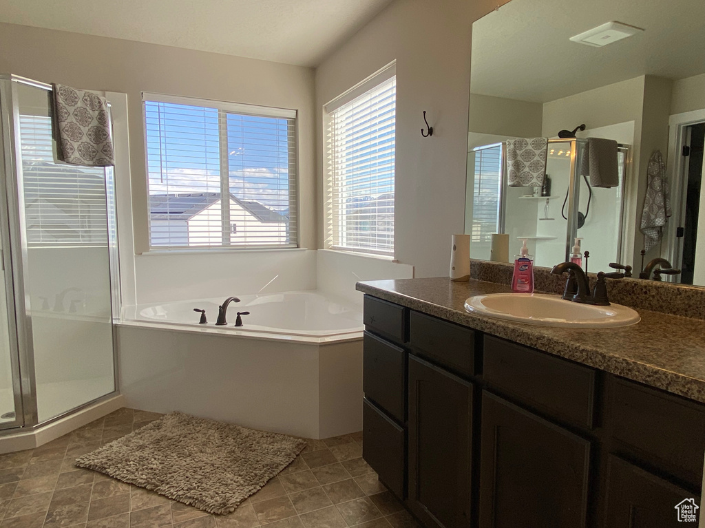 Bathroom with tile flooring, independent shower and bath, and large vanity