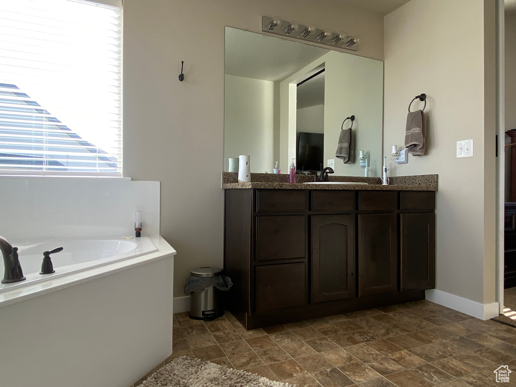 Bathroom featuring tile floors, a bathing tub, and vanity with extensive cabinet space