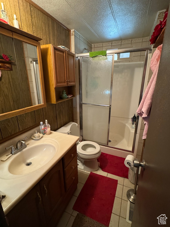 Bathroom with toilet, an enclosed shower, tile floors, a textured ceiling, and vanity