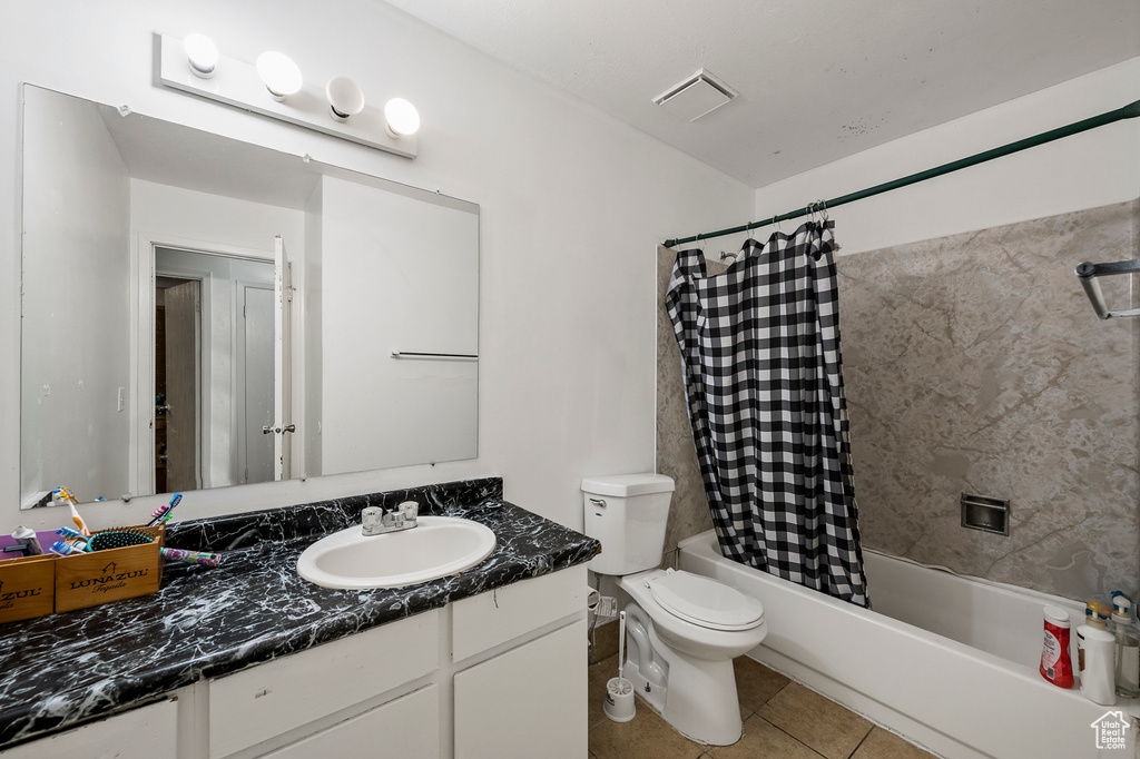 Full bathroom with toilet, vanity, shower / tub combo with curtain, and tile flooring