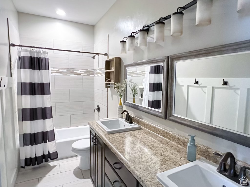 Full bathroom featuring toilet, shower / tub combo with curtain, dual vanity, and tile flooring