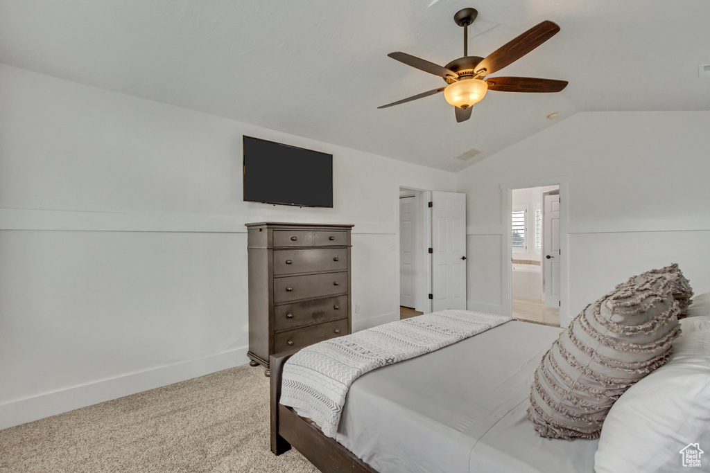 Carpeted bedroom featuring ensuite bathroom, vaulted ceiling, and ceiling fan