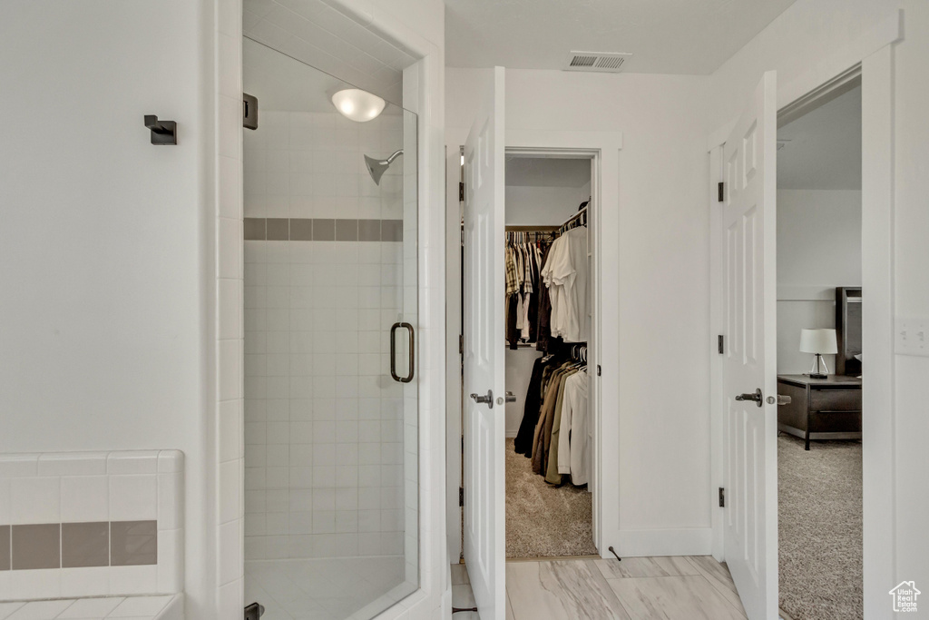 Bathroom with tile flooring and a shower with shower door