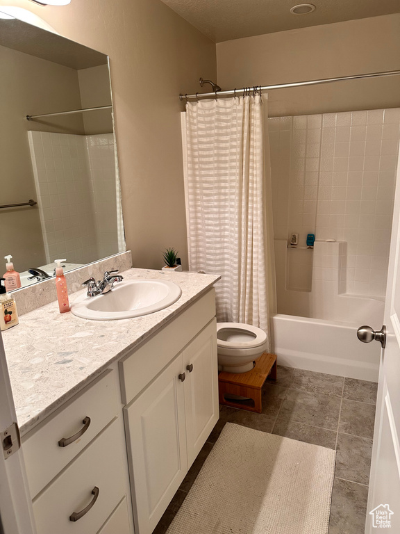 Full bathroom featuring shower / tub combo, toilet, tile floors, and oversized vanity
