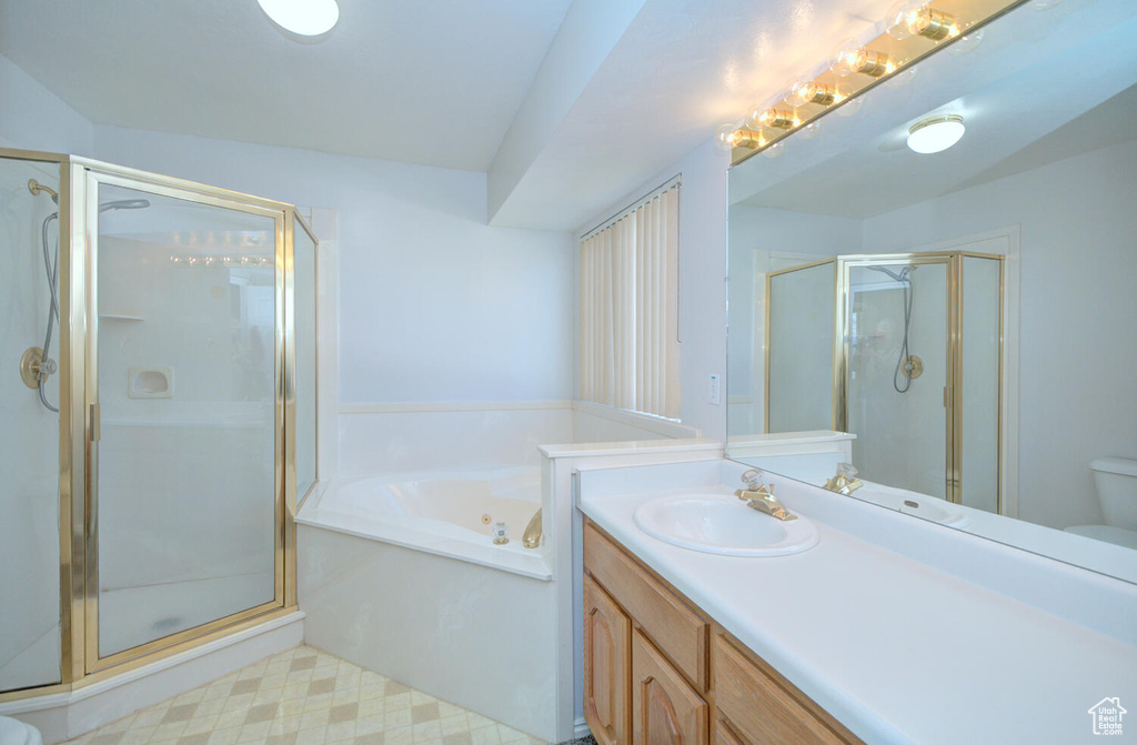 Full bathroom featuring separate shower and tub, oversized vanity, tile floors, and toilet