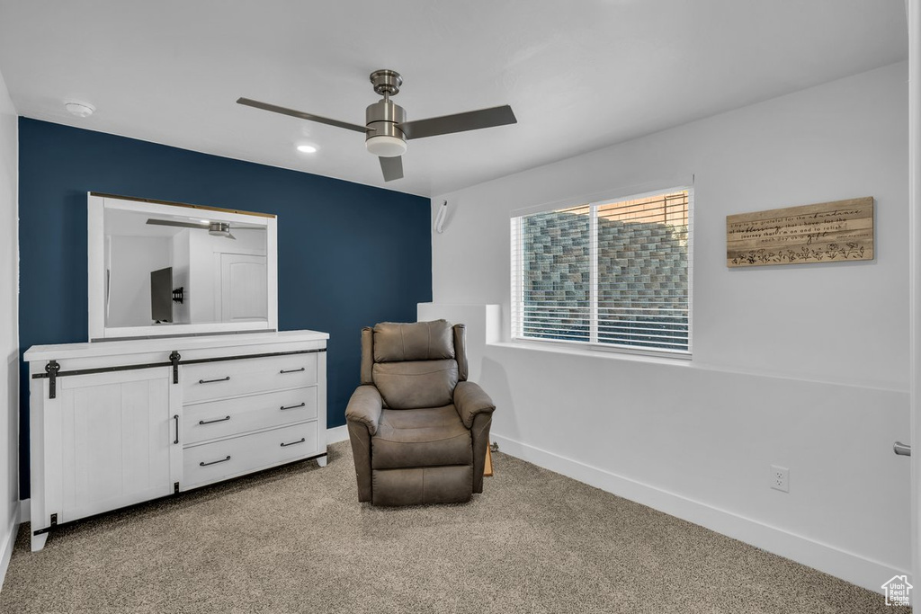Living area featuring ceiling fan and light colored carpet