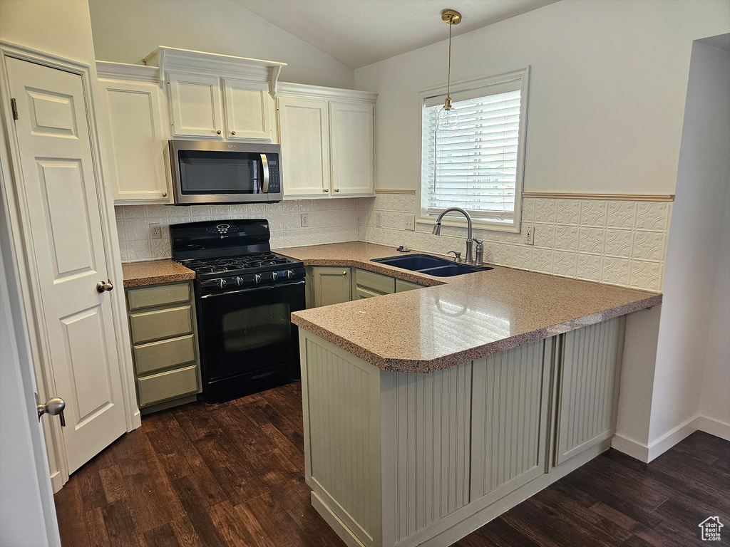 Kitchen with dark hardwood / wood-style floors, sink, kitchen peninsula, and black gas range
