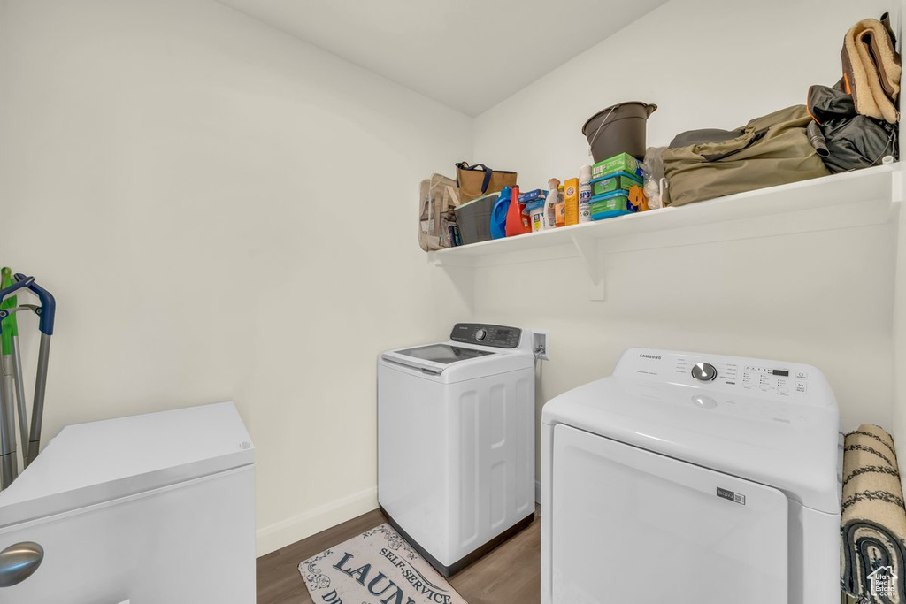 Washroom with independent washer and dryer and dark hardwood / wood-style floors