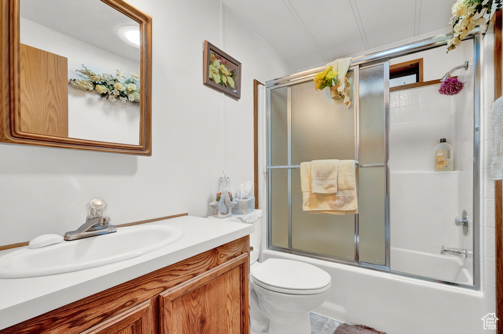 Full bathroom featuring toilet, vanity, shower / bath combination with glass door, and tile flooring
